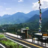 Balkon mit Tischen und Stühlen in Sapa, Vietnam, bietet einen atemberaubenden Blick auf grüne Berge.