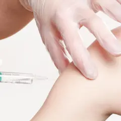Eine Spritze wird in einen Arm injiziert. Informationen zu Thailand Impfungen Kosten sind wichtig für Reisende.