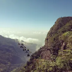 Grüner berg Sri Lanka mit steiler Klippe und Wolkenmeer in der Ferne.