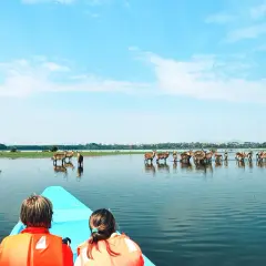 Zwei Kinder in Schwimmwesten blicken auf eine Herde Antilopen im Wasser. Das Wetter in Kenia im September ist perfekt für diese Bootsfahrt.