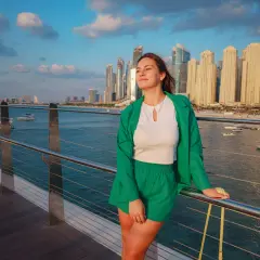 Junge Frau in grüner Kleidung genießt die Aussicht auf die Skyline von Dubai. Keine Sorge wegen Zika-Virus.