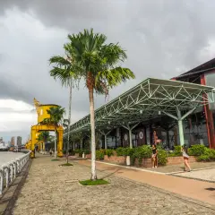 Uferpromenade in Belém, Brasilien, mit Palmen, einem gelben Kran und einem modernen Gebäude.