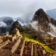 Der Inka-Tempel Machu Picchu, umgeben von nebelverhangenen Bergen, thront majestätisch auf einem Berggipfel.