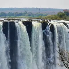 Tosende Victoriafälle stürzen in die Tiefe. Die beste Reisezeit für dieses Naturspektakel ist die Trockenzeit, wenn das Wasser am höchsten steht.