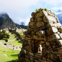 Ruinen von Machu Picchu mit terrassierten Feldern und Bergen im Nebel. Die **Andenkreuz Bedeutung spirituell** wird hier durch die Verbindung von Mensch und Natur spürbar.