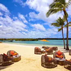 Traumhafter Strand auf Mauritius mit Korbsesseln und Palmen. Keine Mauritius Reisewarnung, nur pure Entspannung am türkisblauen Meer.