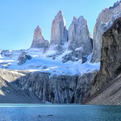 Majestätisches patagonia gebirge mit schneebedeckten Gipfeln, die sich über einem türkisfarbenen See erheben.