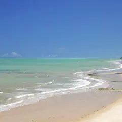 Traumhafter Strand mit türkisfarbenem Wasser und zwei Spaziergängern in Porto Seguro, Bahia.