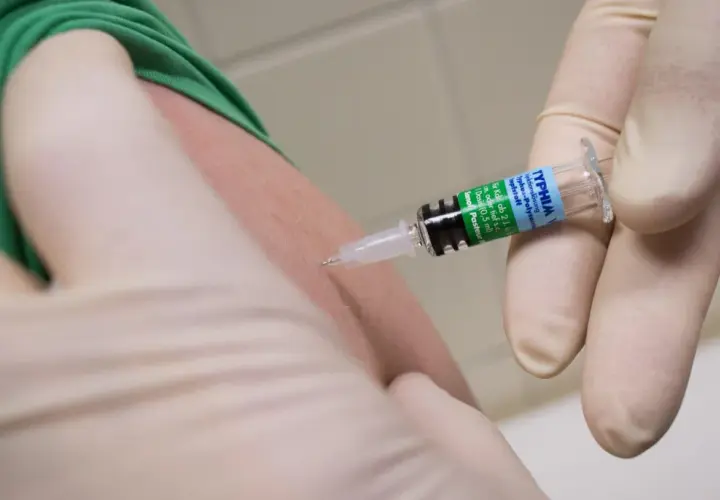 Spritze mit Typhus-Impfstoff wird in den Arm injiziert. Wichtig für Reisen nach Thailand.