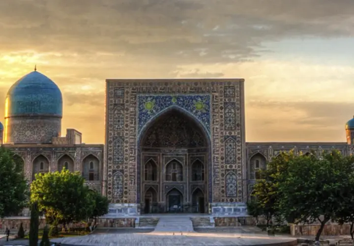 Prachtvolles Gebäude in Usbekistan mit blauen Kuppeln und Mosaiken. Eine Reise dorthin ist trotz der Schönheit lohnenswert, aber eine Usbekistan Reisewarnung sollte beachtet werden.