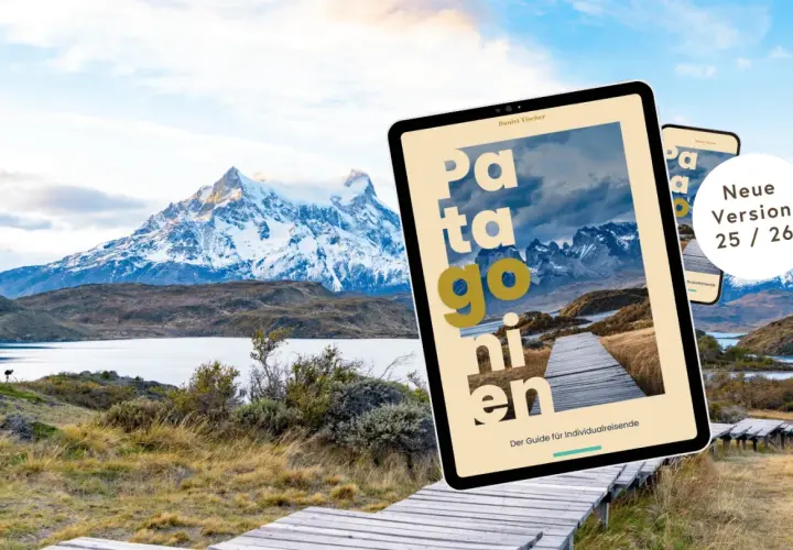 Ein Tablet mit dem Titel "Patagonien" liegt vor einer atemberaubenden Berglandschaft. Der Reiseführer ist die neue Version 25/26.
