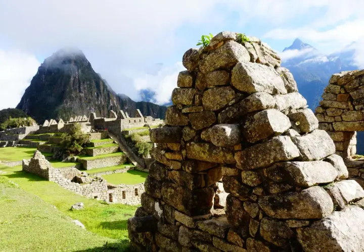 Ruinen von Machu Picchu mit terrassierten Feldern und Bergen im Nebel. Die **Andenkreuz Bedeutung spirituell** wird hier durch die Verbindung von Mensch und Natur spürbar.