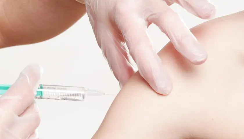 Eine Spritze wird in einen Arm injiziert. Informationen zu Thailand Impfungen Kosten sind wichtig für Reisende.