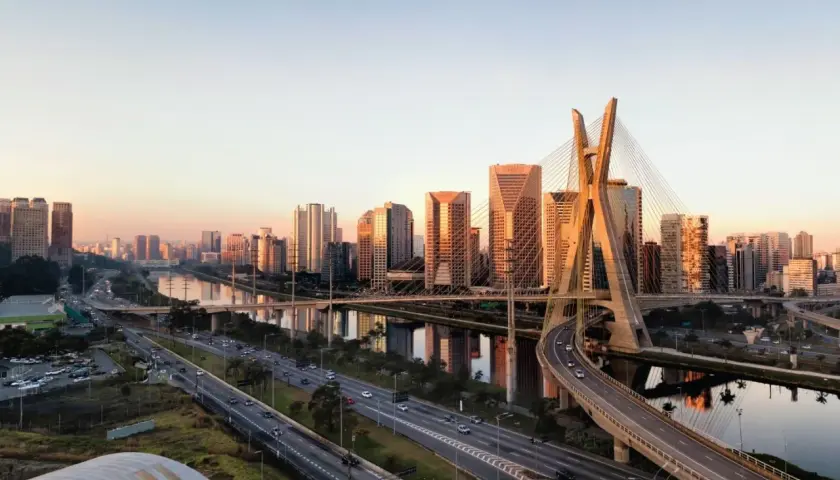 Sonnenuntergang über der Skyline von Brasilien, São Paulo. Die Ponte Estaiada, ein Wahrzeichen der Stadt, spiegelt sich im Fluss.