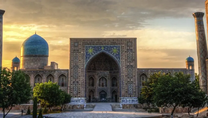 Prachtvolles Gebäude in Usbekistan mit blauen Kuppeln und Mosaiken. Eine Reise dorthin ist trotz der Schönheit lohnenswert, aber eine Usbekistan Reisewarnung sollte beachtet werden.