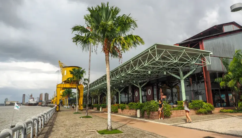 Uferpromenade in Belém, Brasilien, mit Palmen, einem gelben Kran und einem modernen Gebäude.