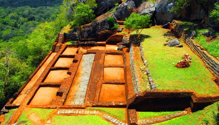Ruinen der alten Festung Sigiriya Sri Lanka, mit Terrassen, Mauern und Treppen, umgeben von üppiger Vegetation.