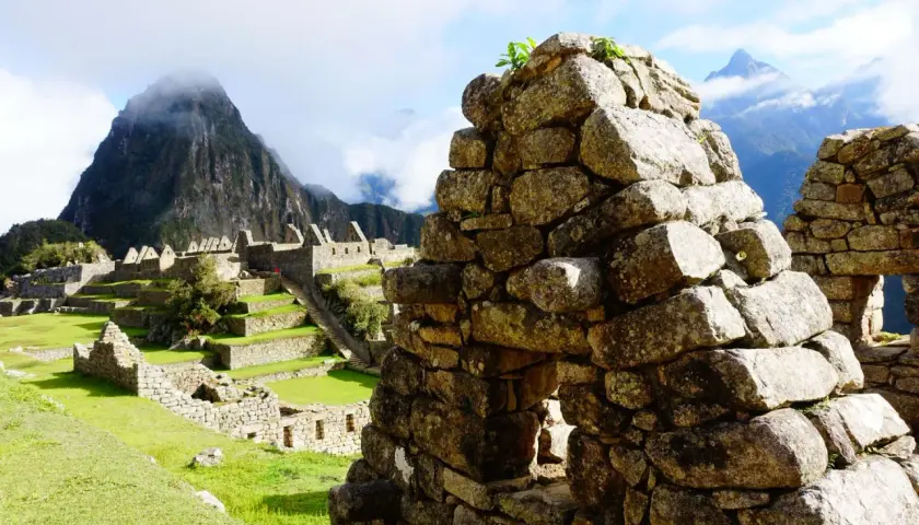 Ruinen von Machu Picchu mit terrassierten Feldern und Bergen im Nebel. Die **Andenkreuz Bedeutung spirituell** wird hier durch die Verbindung von Mensch und Natur spürbar.