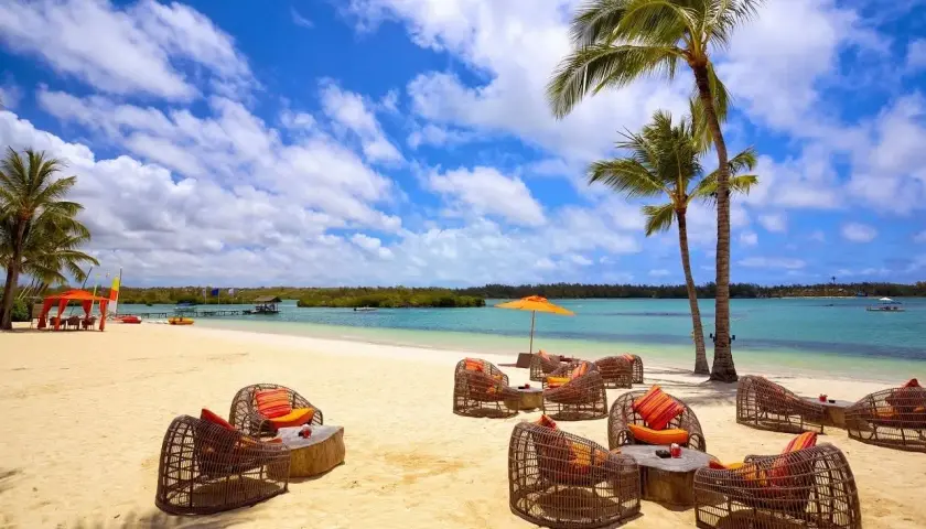Traumhafter Strand auf Mauritius mit Korbsesseln und Palmen. Keine Mauritius Reisewarnung, nur pure Entspannung am türkisblauen Meer.