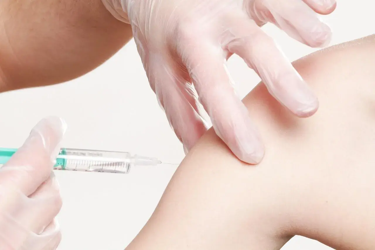 Eine Spritze wird in einen Arm injiziert. Informationen zu Thailand Impfungen Kosten sind wichtig für Reisende.