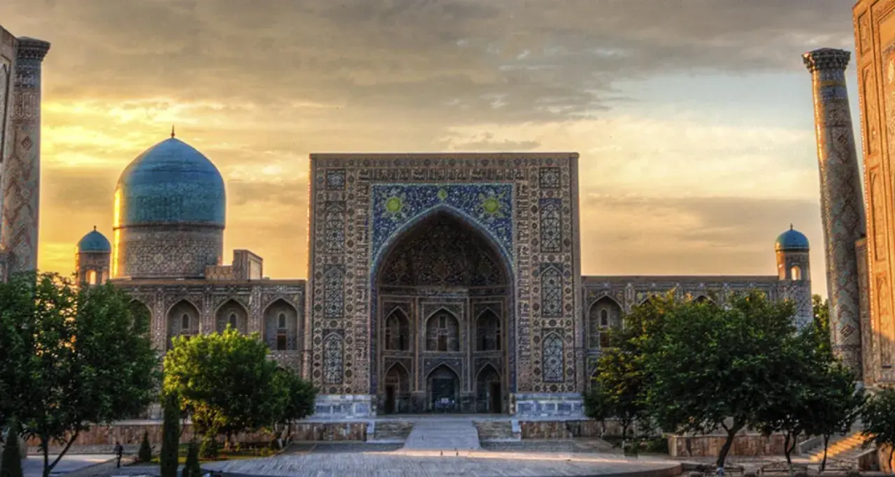 Prachtvolles Gebäude in Usbekistan mit blauen Kuppeln und Mosaiken. Eine Reise dorthin ist trotz der Schönheit lohnenswert, aber eine Usbekistan Reisewarnung sollte beachtet werden.