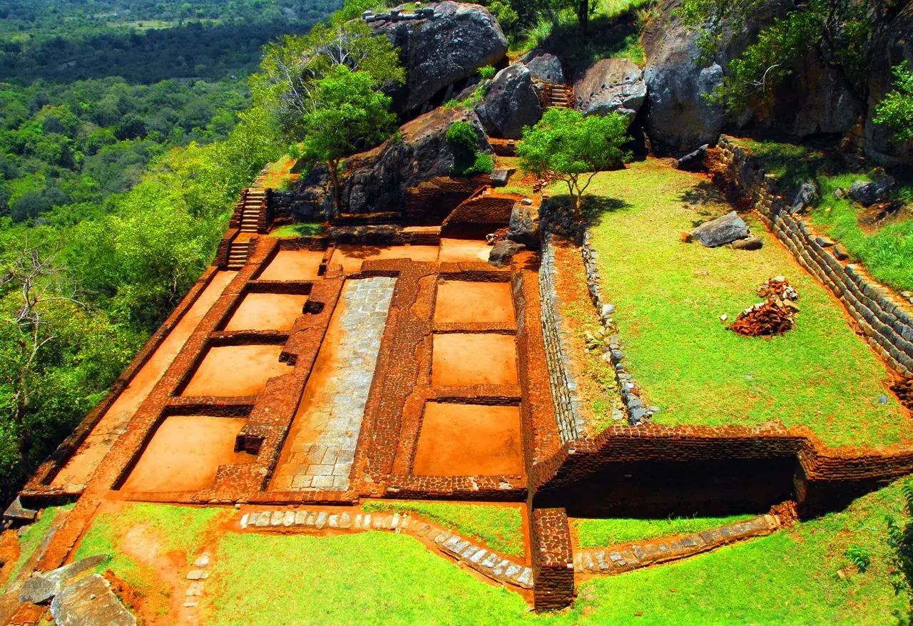 Ruinen der alten Festung Sigiriya Sri Lanka, mit Terrassen, Mauern und Treppen, umgeben von üppiger Vegetation.