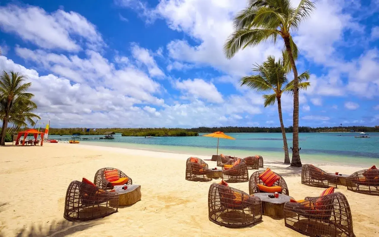Traumhafter Strand auf Mauritius mit Korbsesseln und Palmen. Keine Mauritius Reisewarnung, nur pure Entspannung am türkisblauen Meer.
