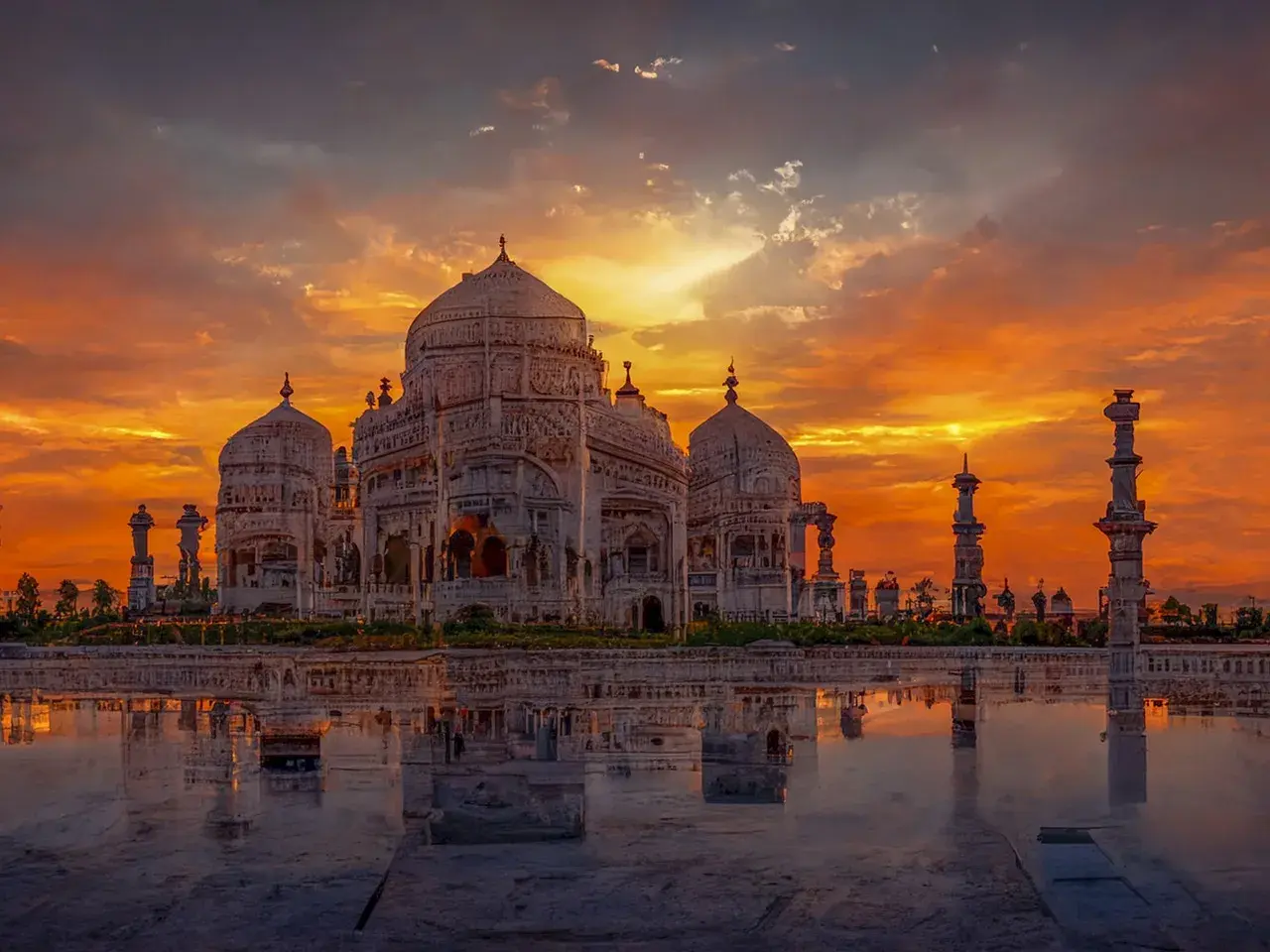 Das Taj Mahal spiegelt sich im Wasser, während ein dramatischer Sonnenuntergang den Himmel in leuchtenden Orange- und Rottönen färbt.