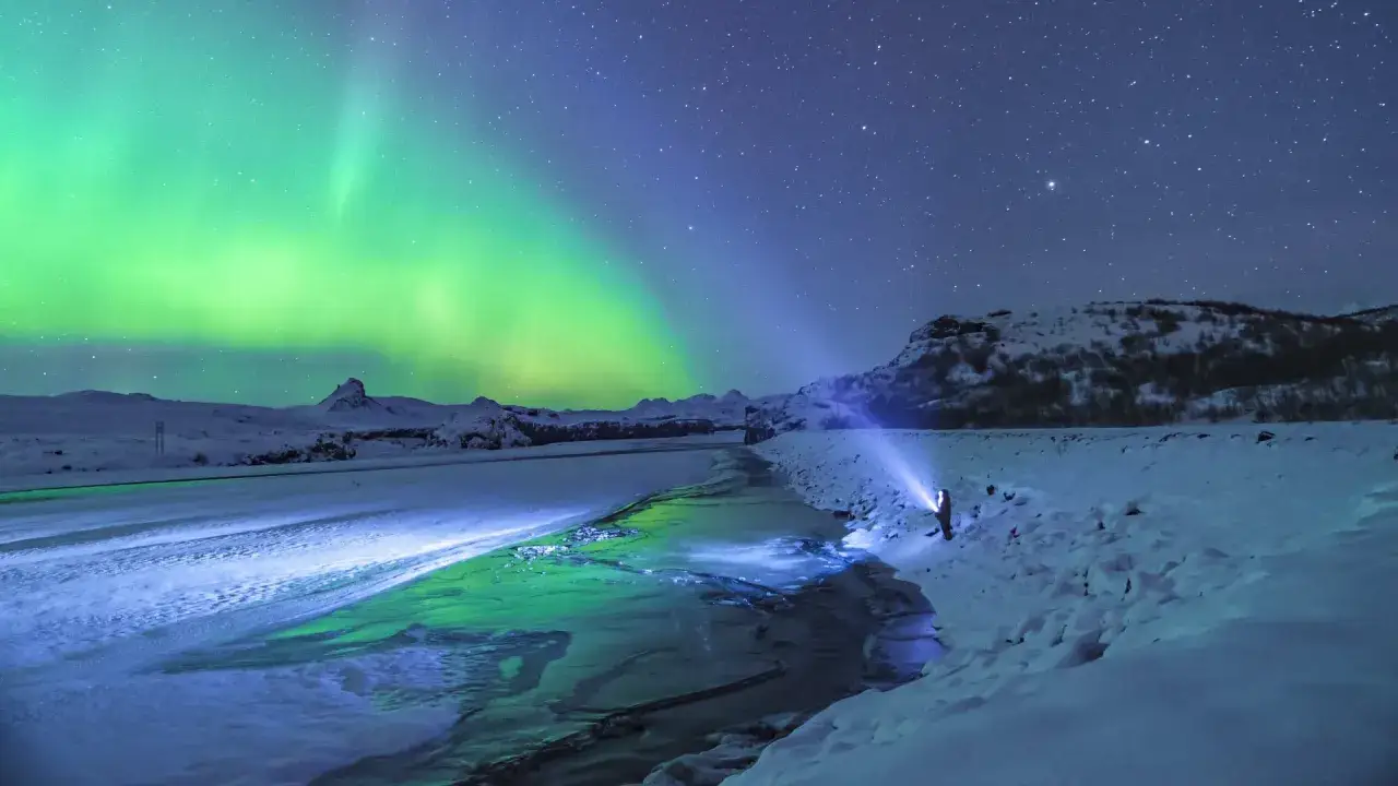 Island: Polarlichter tanzen über gefrorene Landschaft. Eine perfekte Reisezeit für dieses Naturschauspiel.