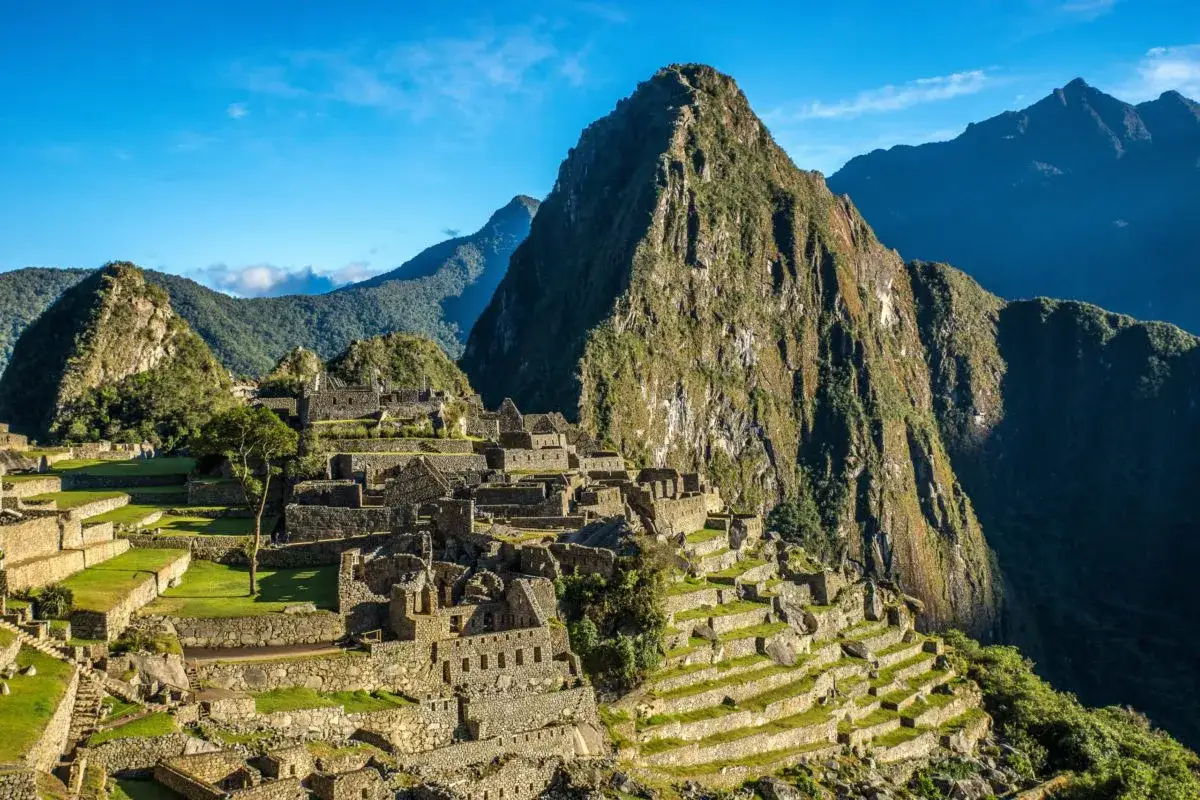 Der Inka-Tempel Machu Picchu thront majestätisch auf einem Berggipfel, umgeben von grünen Terrassen und steilen Bergen.