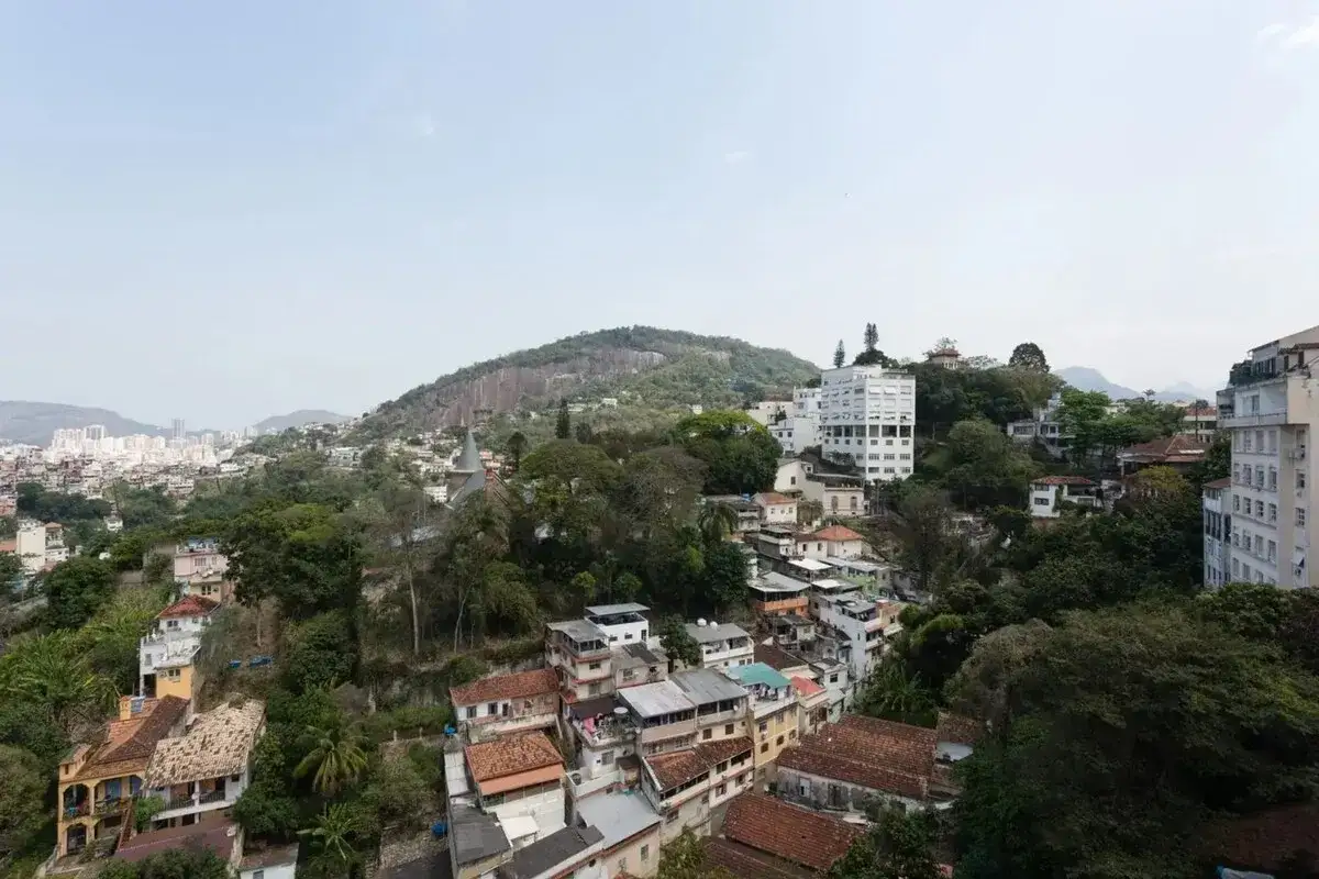 Bunte H&auml;user schmiegen sich an gr&uuml;ne H&uuml;gel in Santa Teresa, Rio. Ein Blick &uuml;ber die Stadt mit dem markanten Berg im Hintergrund.