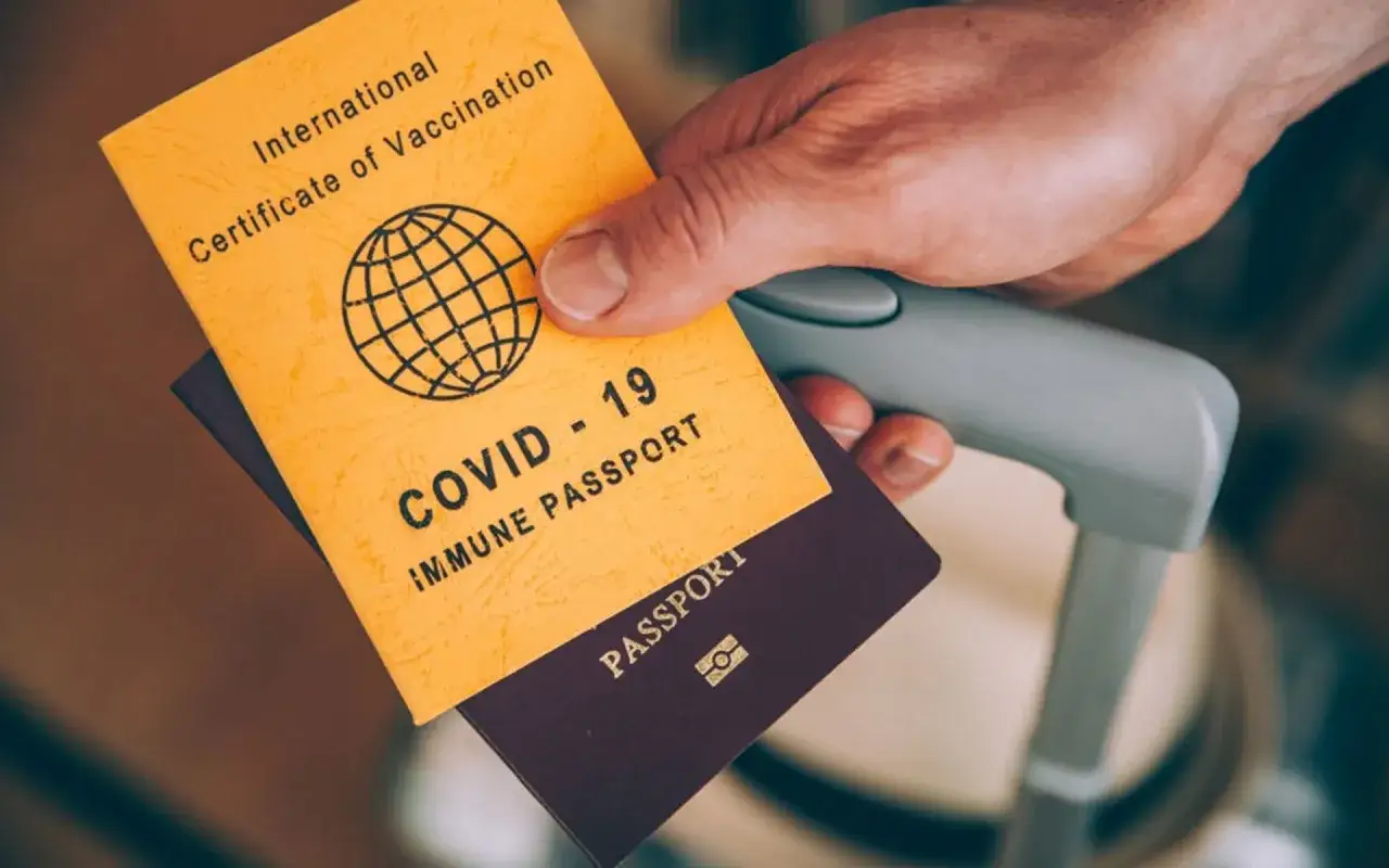 Ein Reisender hält einen COVID-19-Impfnachweis und einen Reisepass. Dies ist wichtig für Reisen nach Vietnam.