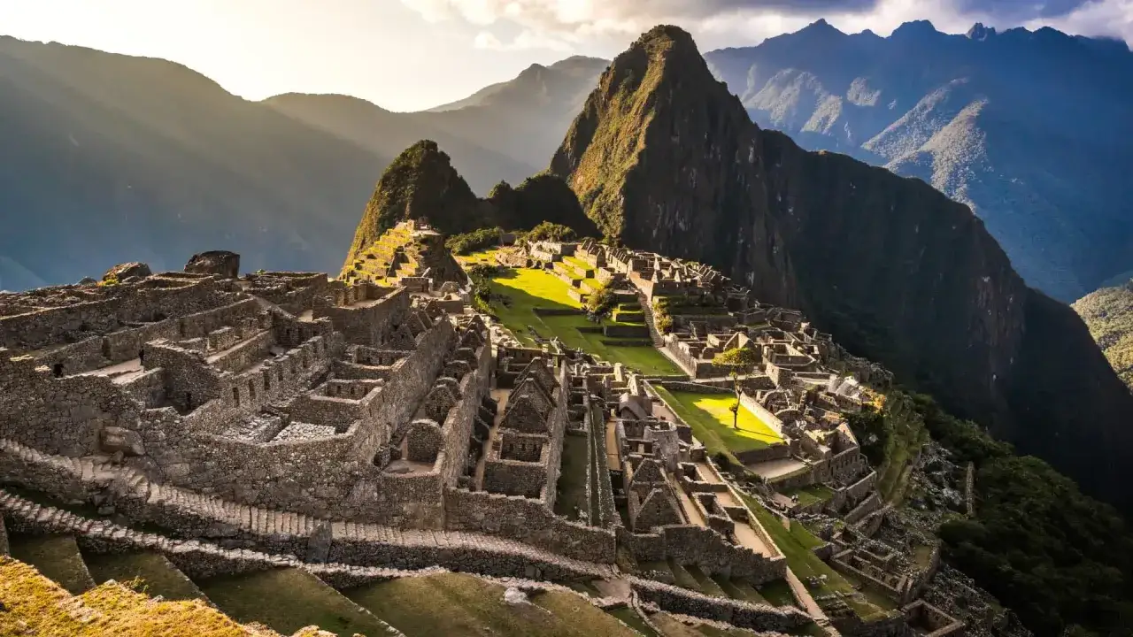 Sonnenstrahlen beleuchten die Ruinen von Machu Picchu, eine beeindruckende Inka-Stadt in den Anden. Was ist Machu Picchu? Ein mystischer Ort voller Geschichte.