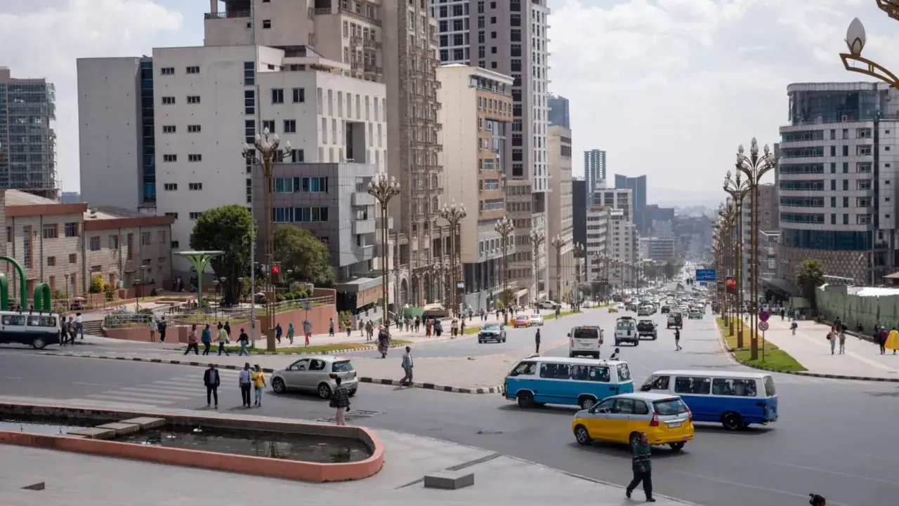 Belebte Straße in Addis Abeba mit vielen Autos und Fußgängern. Die moderne Architektur und der Verkehr deuten auf eine geschäftige Stadt hin, in der die addis abeba sicherheit gewährleistet ist.