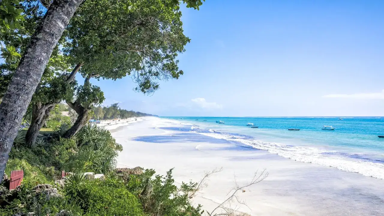 Traumhafter Strand in Kenia: Die beste Reisezeit für Safari und Baden. Türkises Meer, weiße Sandstrände und Boote laden zum Entspannen ein.