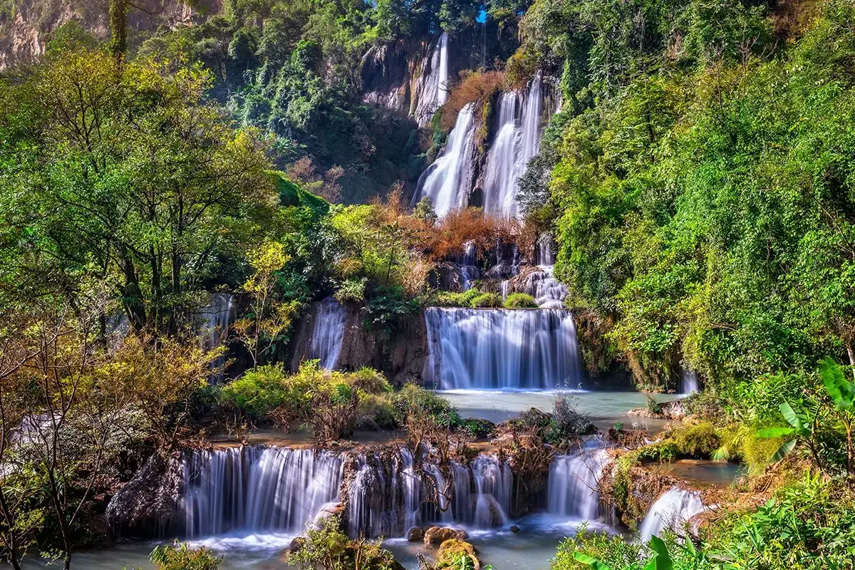 Majestätische Wasserfälle stürzen durch üppige Vegetation in einem thailändischen Nationalpark. Ein wahres Naturwunder!